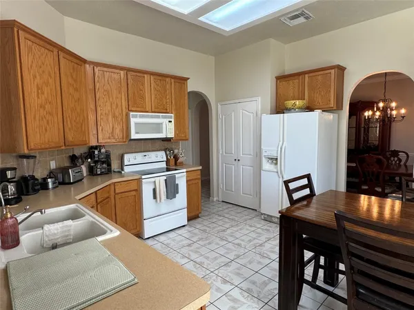 a kitchen with granite countertop wooden cabinets and stainless steel appliances