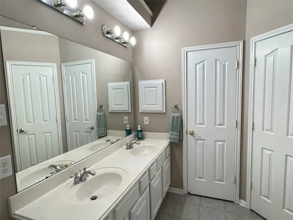 a bathroom with a double vanity sink and a mirror