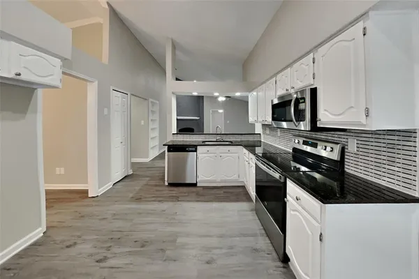 a kitchen with stainless steel appliances a stove sink microwave and cabinets