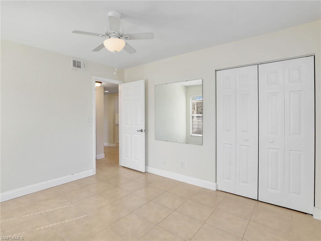 744 Landover Circle, Unit 101 Naples, FL 34104 - Photo 17 of 24 an empty room with fan and a ceiling fan