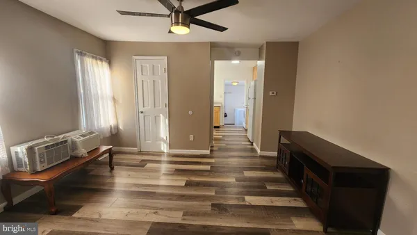 a view of a hallway with wooden floor and staircase