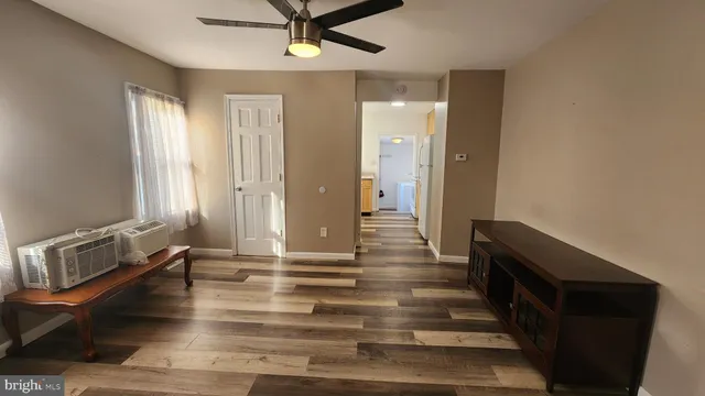 a view of a hallway with wooden floor and staircase