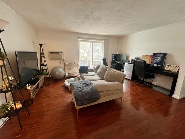 a living room with furniture a flat screen tv and a window