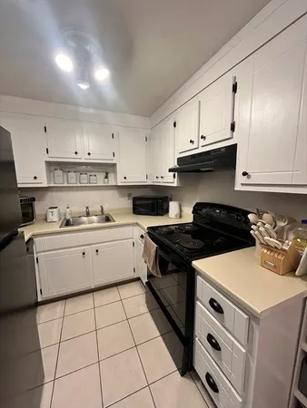 a kitchen with a stove a sink and a refrigerator