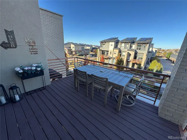 a balcony with wooden floor table and chairs
