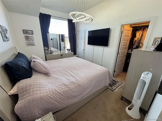 a bedroom with a bed tv and a window