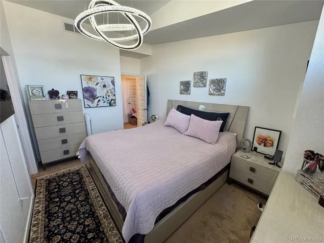 a bedroom with a bed and a large mirror on the dresser