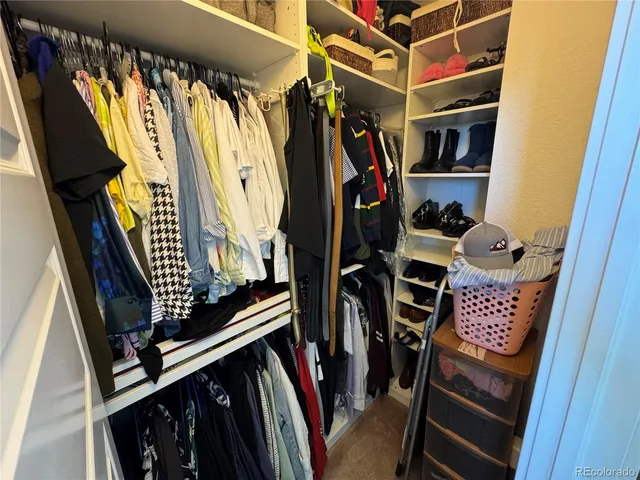 a view of walk in closet with clothes