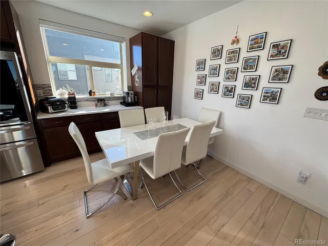 a dining room with wooden floor and large windows