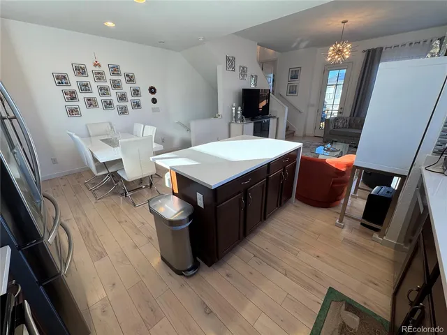 a kitchen with a wooden floor and chairs