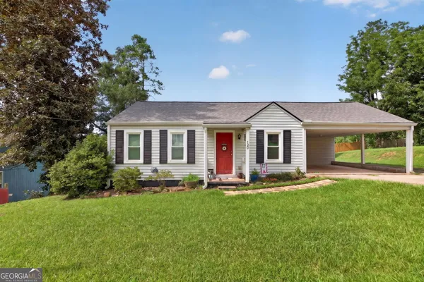 a front view of a house with a yard and trees