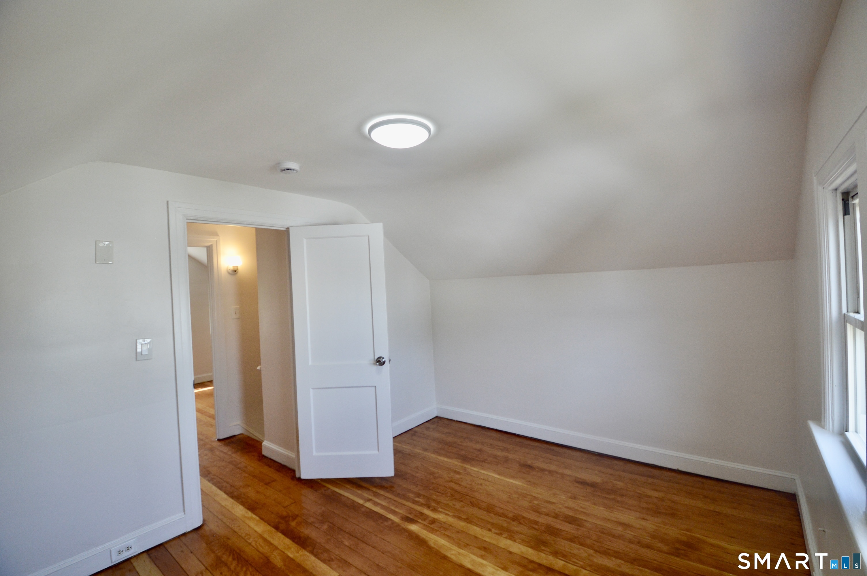 314 Knowlton Street Stratford, CT 06615 - Photo 17 of 26 an empty room with wooden floor and windows