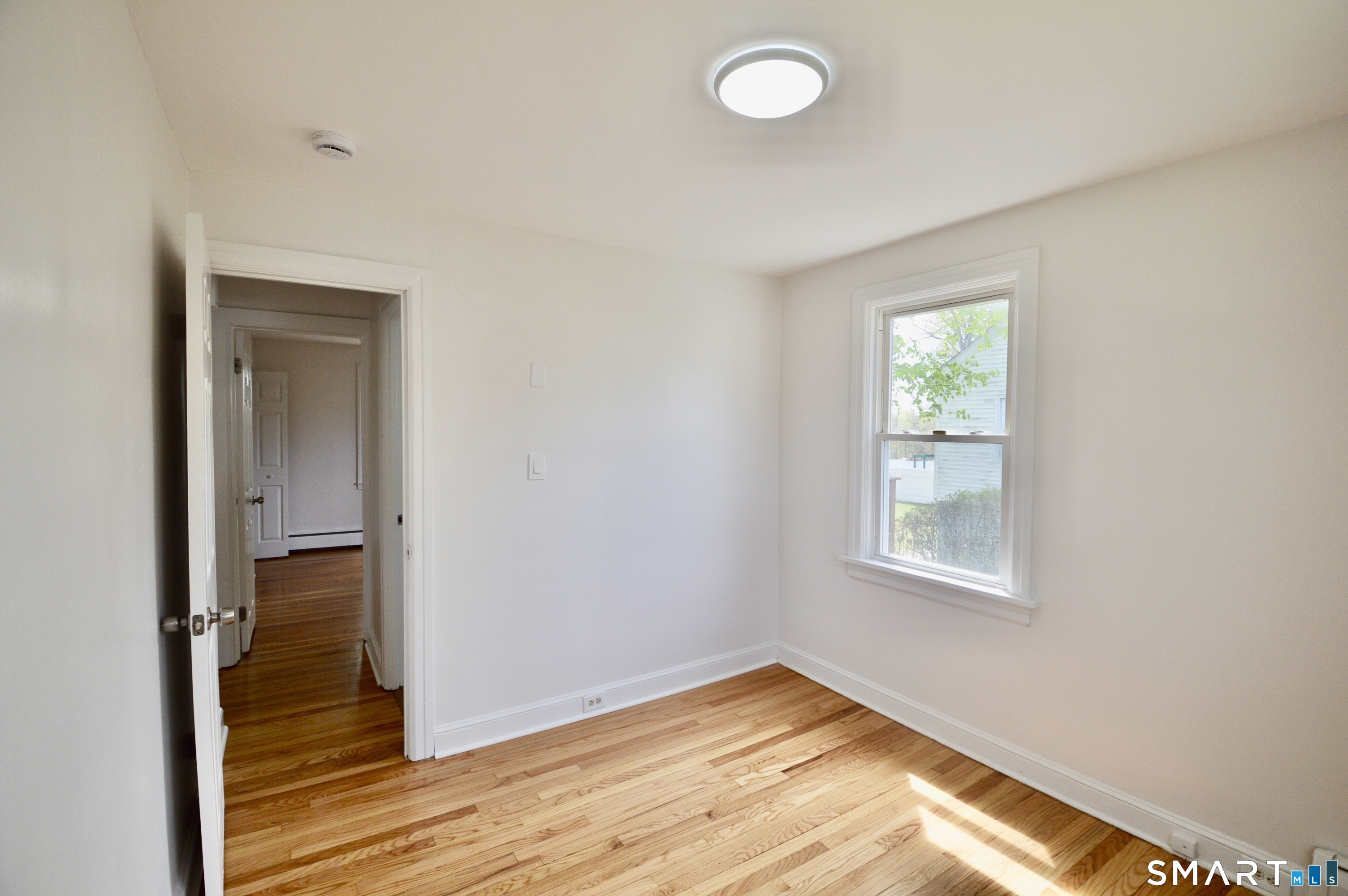 314 Knowlton Street Stratford, CT 06615 - Photo 10 of 26 wooden floor in an empty room with a window