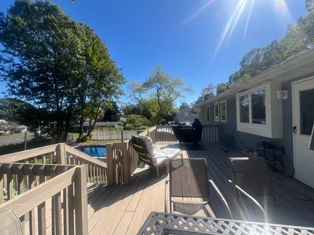 a view of a patio with table and chairs with wooden floor and fence