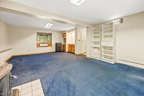 a view of empty room with a fireplace and window