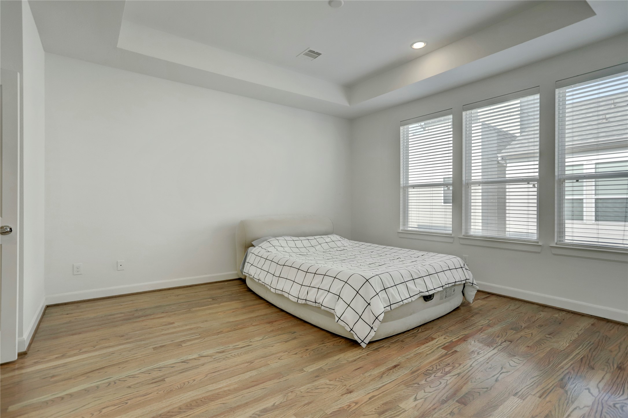 954 West 18th Street Houston, TX 77008 - Photo 14 of 30 Escape to the third floor Primary Suite, where you will be greeted by tray ceilings, engineered hardwood floors, and continued natural light.