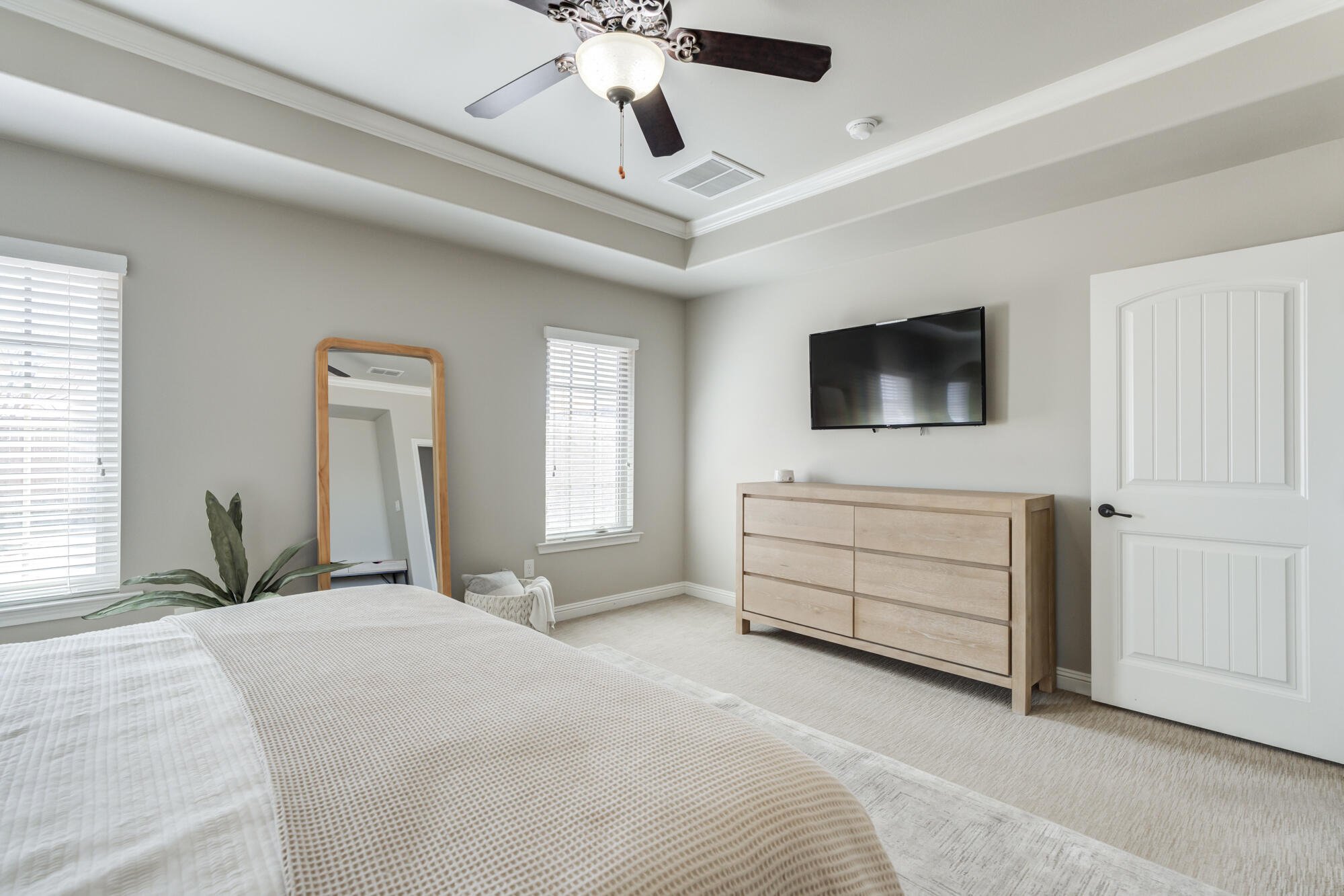 4003 128th Street Lubbock, TX 79423 - Photo 13 of 16 a bedroom with a bed a flat screen tv and a chandelier