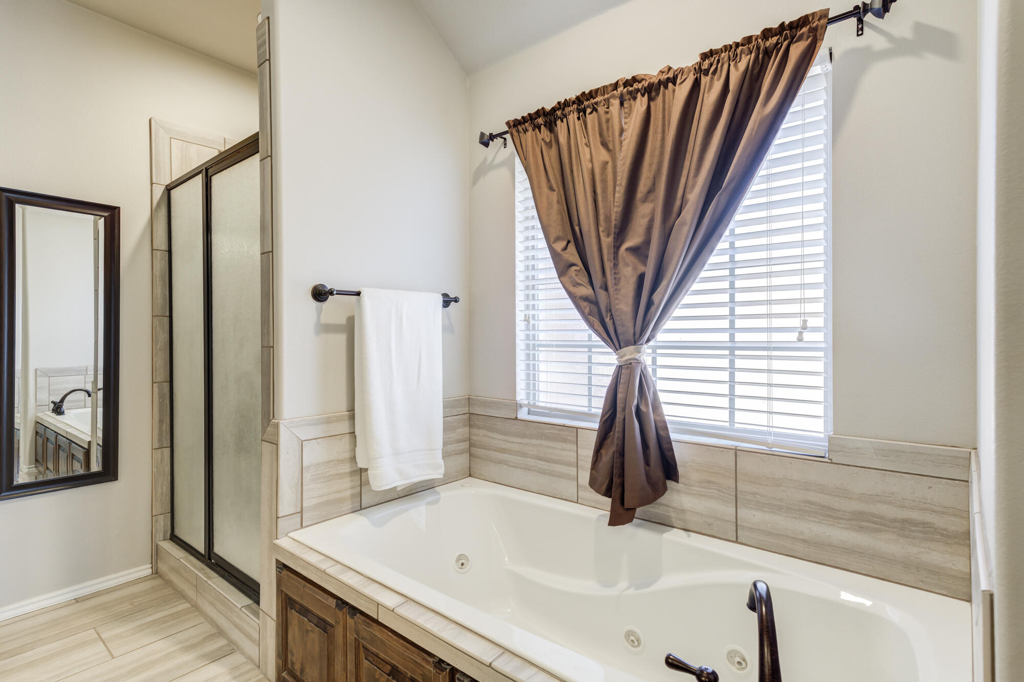 4003 128th Street Lubbock, TX 79423 - Photo 15 of 16 a bathroom with a sink a bathtub and a window