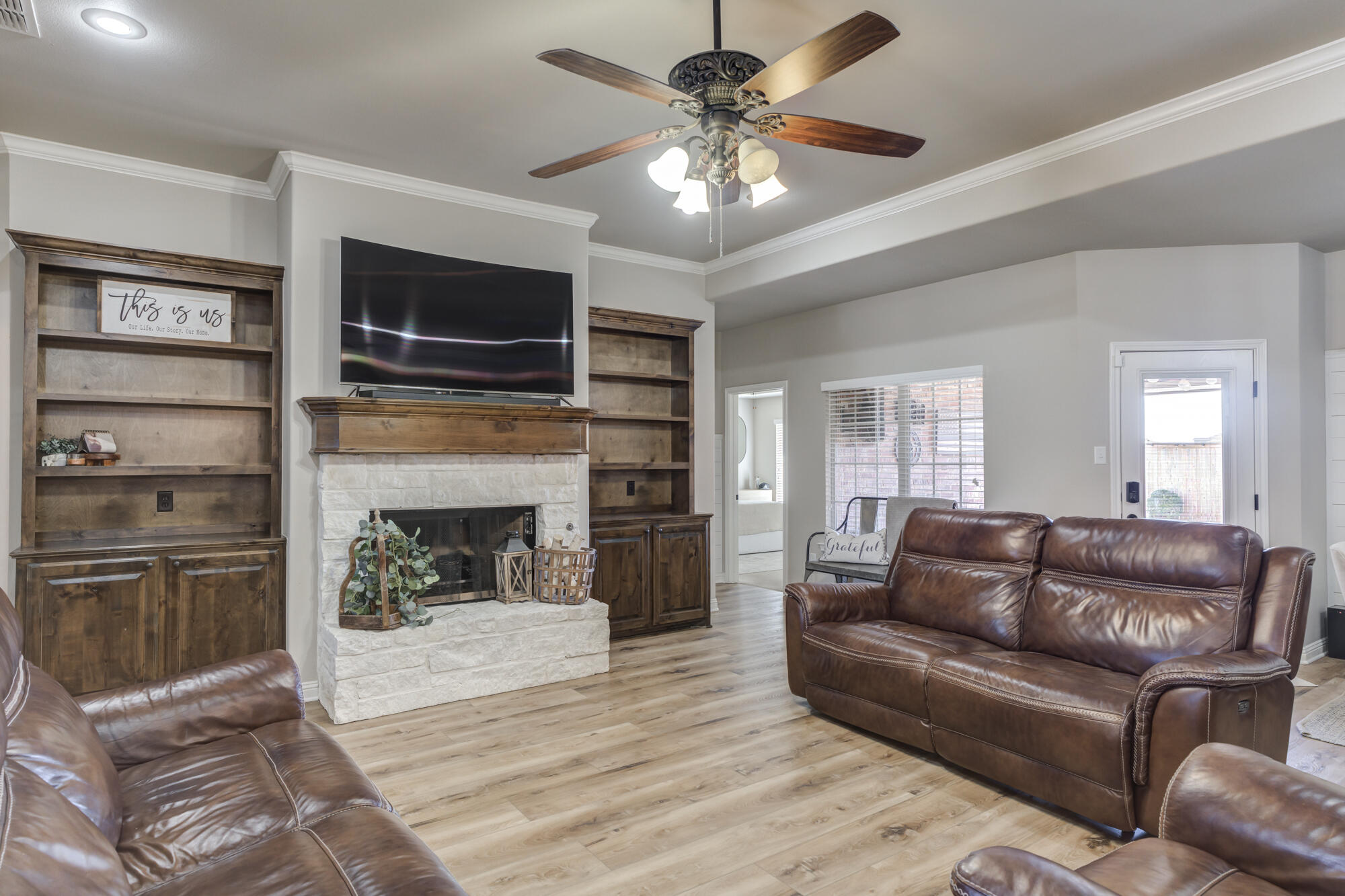 4003 128th Street Lubbock, TX 79423 - Photo 3 of 16 a living room with furniture a flat screen tv and a fireplace