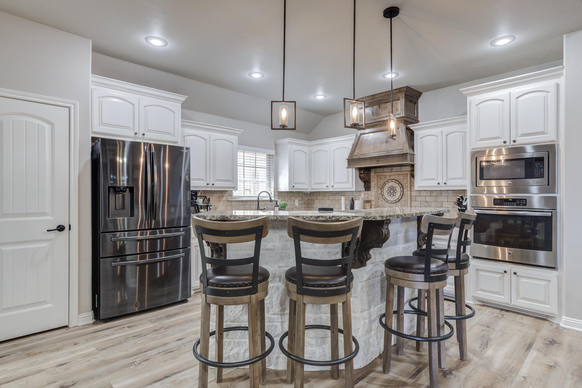 4003 128th Street Lubbock, TX 79423 - Photo 5 of 16 a kitchen with stainless steel appliances a refrigerator a stove a sink dishwasher a dining table and chairs with wooden floor