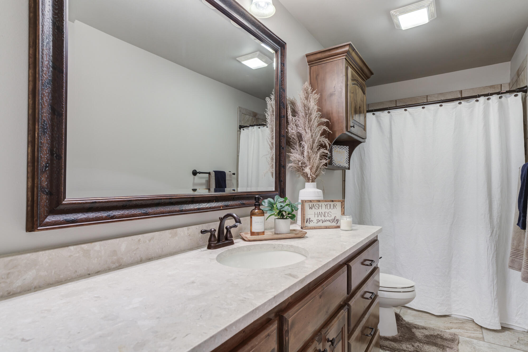 4003 128th Street Lubbock, TX 79423 - Photo 8 of 16 a bathroom with a sink and a mirror