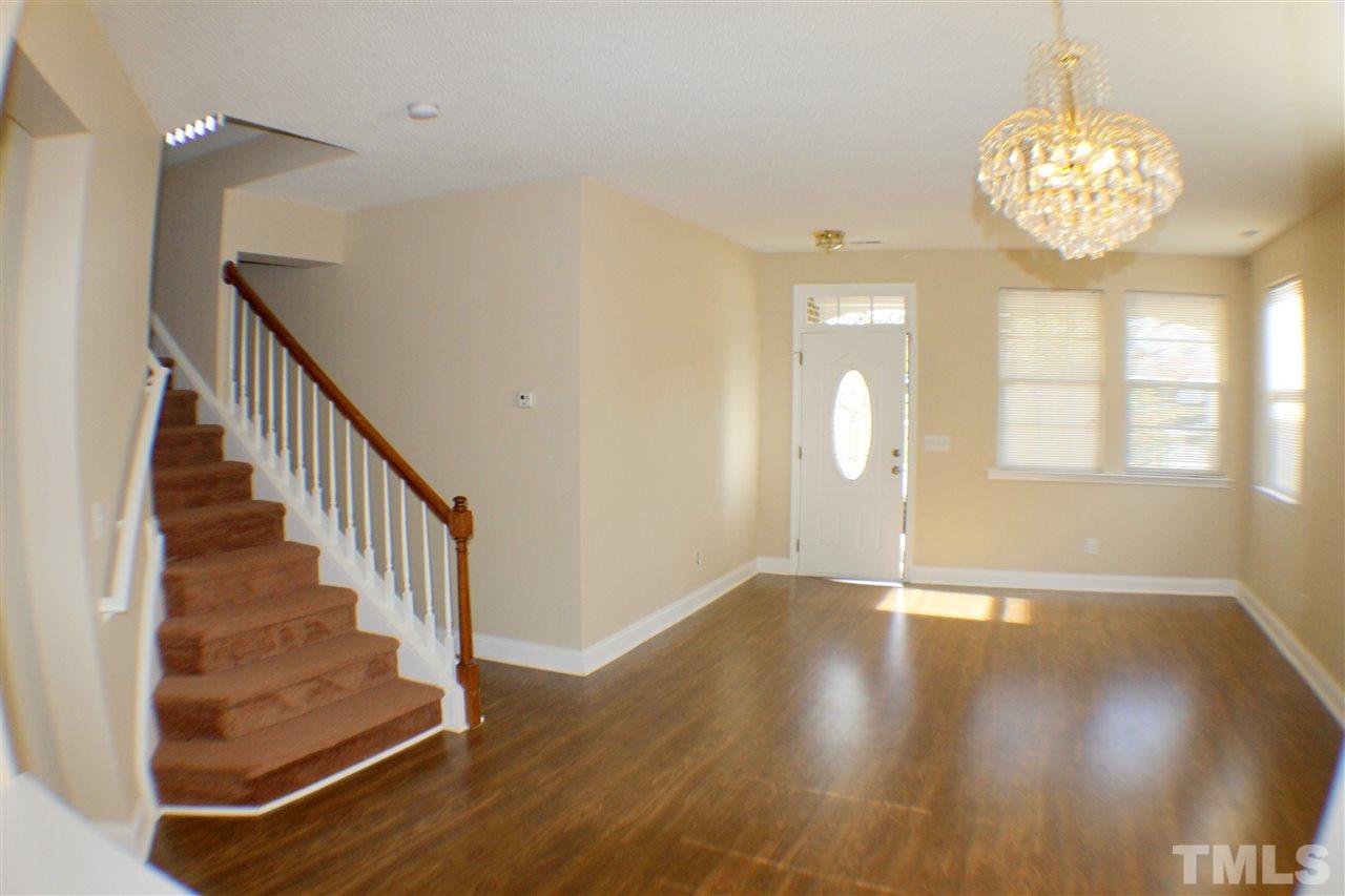 2856 Roundleaf Court Raleigh, NC 27604 - Photo 13 of 24 a view of an empty room with wooden floor and a chandelier