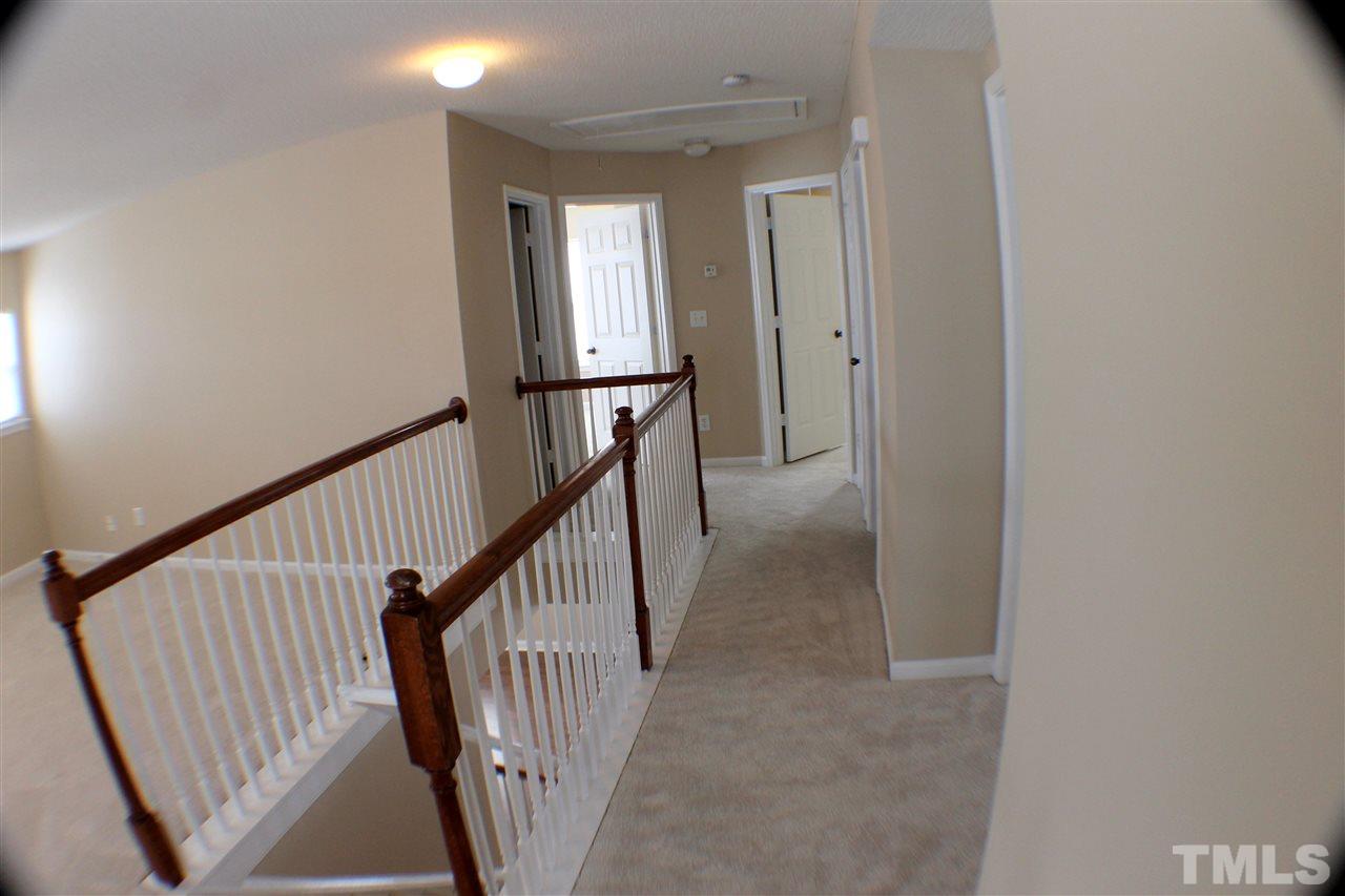 2856 Roundleaf Court Raleigh, NC 27604 - Photo 18 of 24 a view of a hallway with wooden floor and stairs