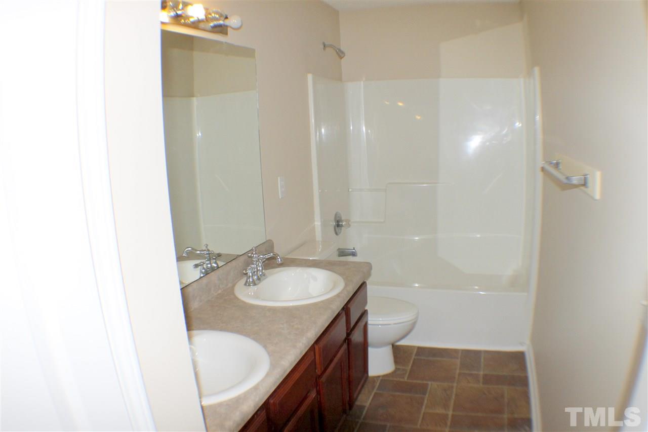2856 Roundleaf Court Raleigh, NC 27604 - Photo 24 of 24 a bathroom with a granite countertop sink a toilet a mirror and shower