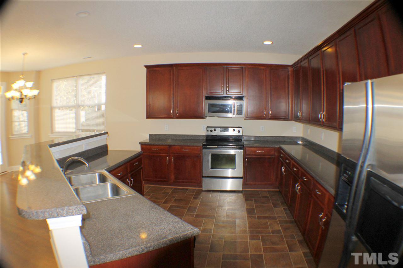 2856 Roundleaf Court Raleigh, NC 27604 - Photo 9 of 24 a kitchen with stainless steel appliances granite countertop a sink stove and refrigerator
