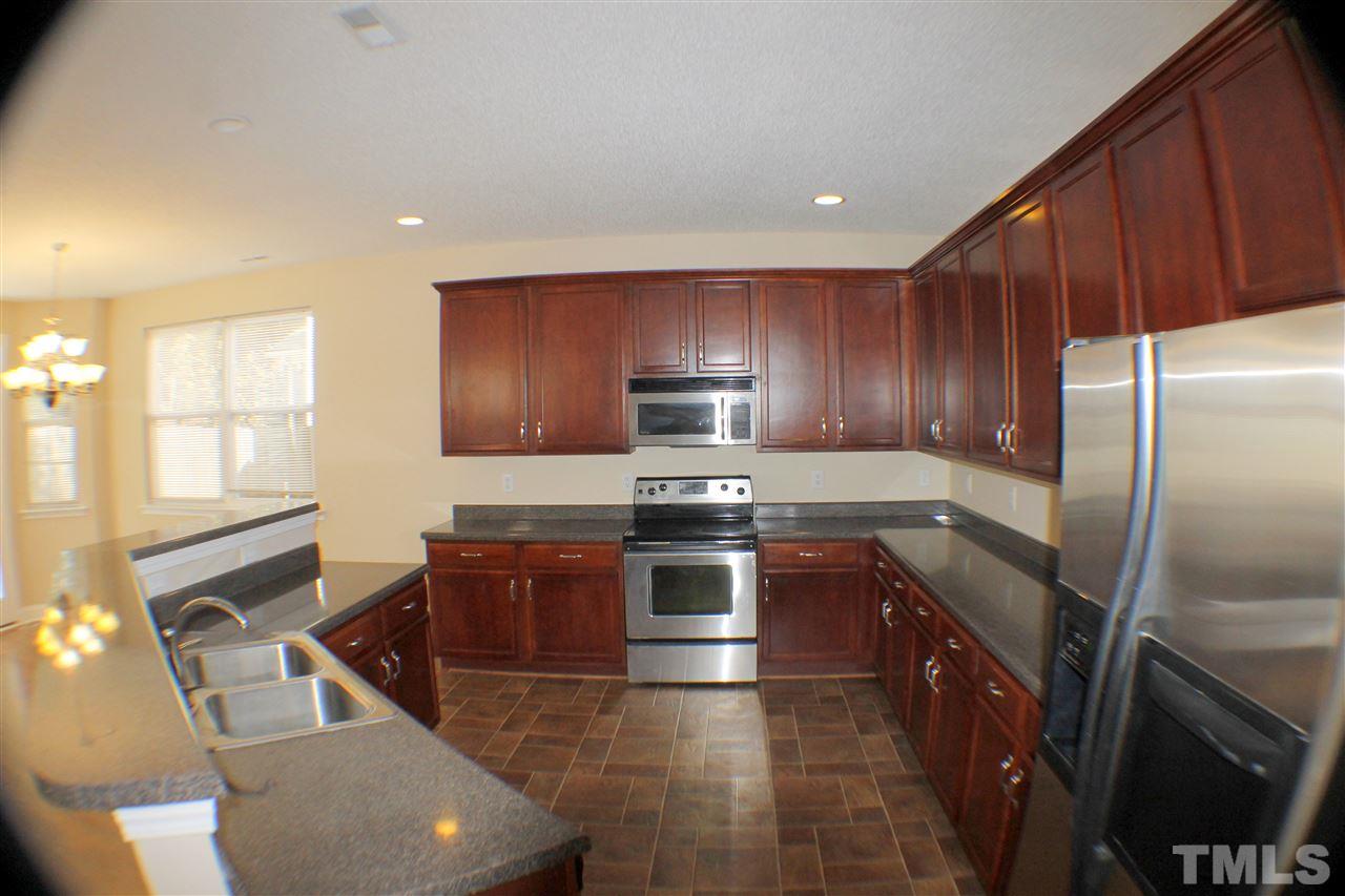 2856 Roundleaf Court Raleigh, NC 27604 - Photo 10 of 24 a kitchen with wooden cabinets and stainless steel appliances