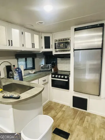 a kitchen with kitchen island a sink stove and refrigerator