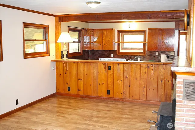 a view of a kitchen with wooden floor and a large window