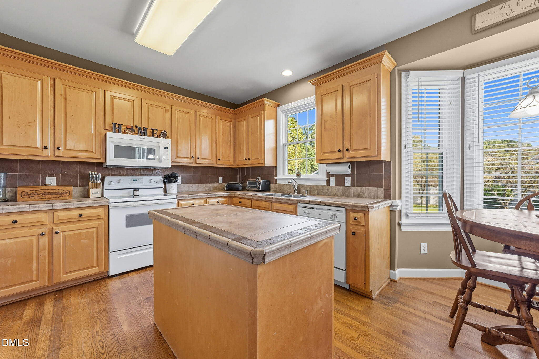 1617 Kendall Hill Road Willow Spring, NC 27592 - Photo 35 of 58 a kitchen with granite countertop wooden floors and white stainless steel appliances