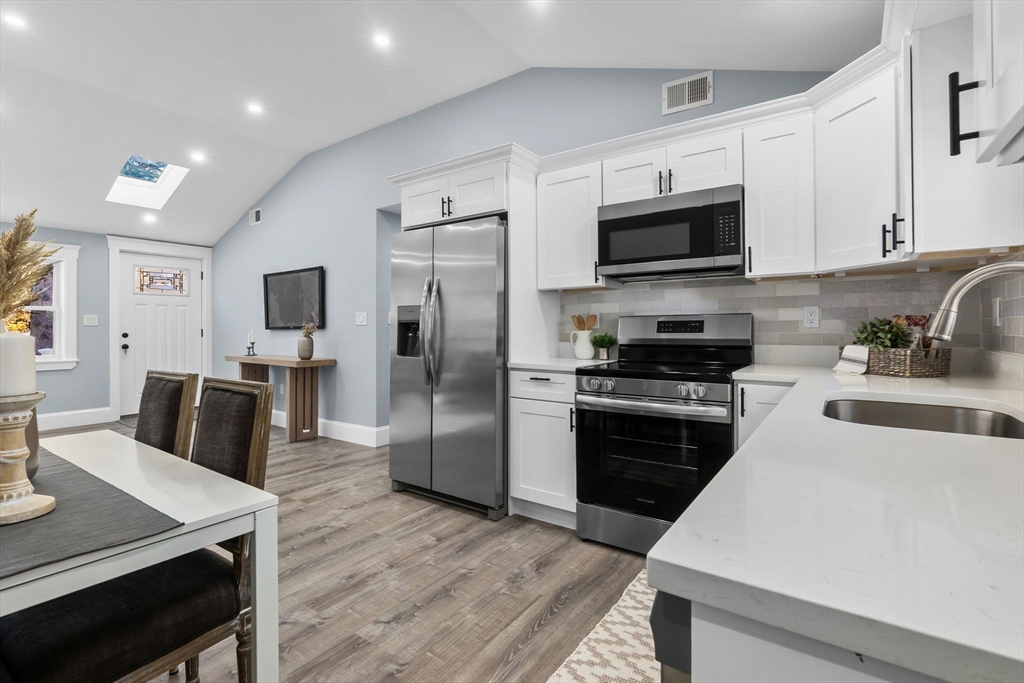 106 Hull Street Beverly, MA 01915 - Photo 4 of 34 a kitchen with stainless steel appliances a stove microwave sink refrigerator and cabinets