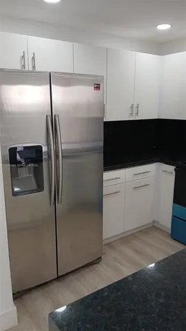 a view of a room with wooden floor and furniture
