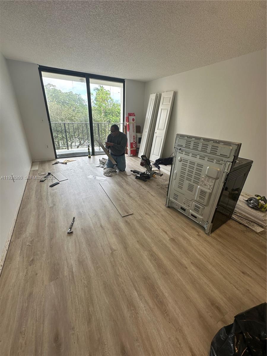 9682 Fontainebleau Boulevard, Unit 312 Miami, FL 33172 - Photo 30 of 33 a view of a room with wooden floor and furniture