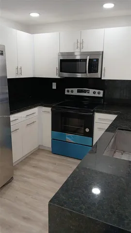 a view of kitchen with microwave and cabinets