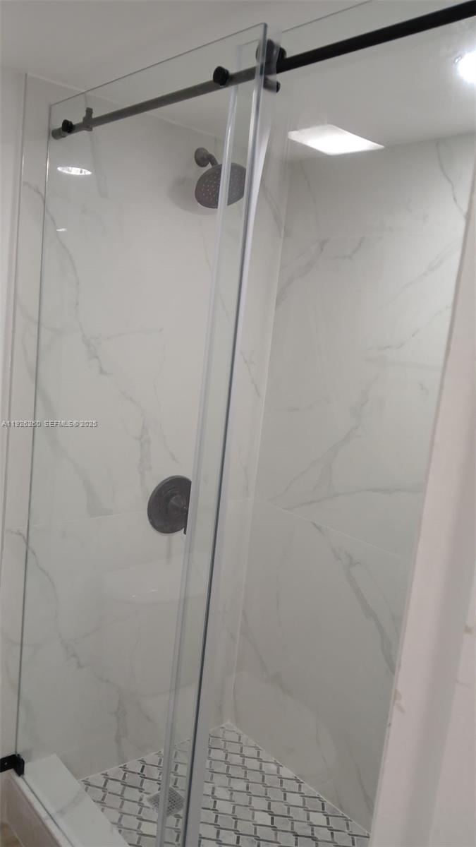 9682 Fontainebleau Boulevard, Unit 312 Miami, FL 33172 - Photo 8 of 33 a bathroom with a glass shower door