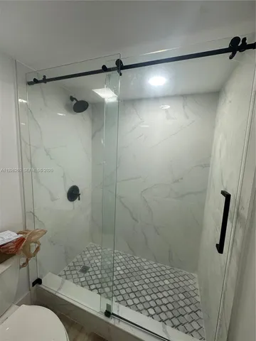 a white toilet sitting next to a shower