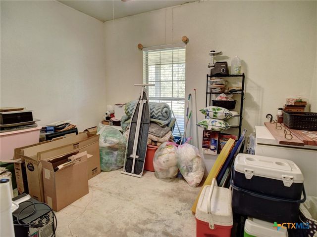 a bedroom with furniture a flat screen tv and a window
