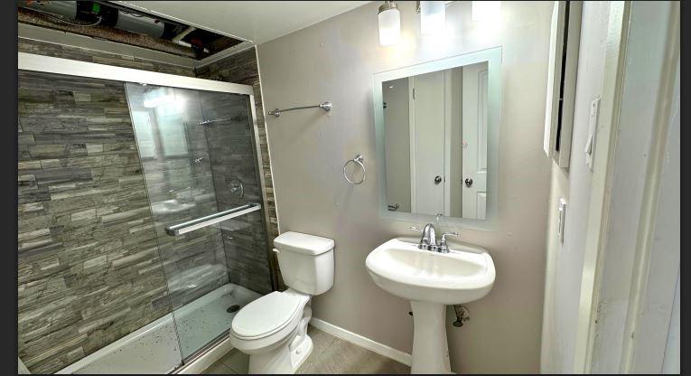 8110 Skillman Street, Unit 2057 Dallas, TX 75231 - Photo 9 of 16 Bathroom with a stall shower and toilet