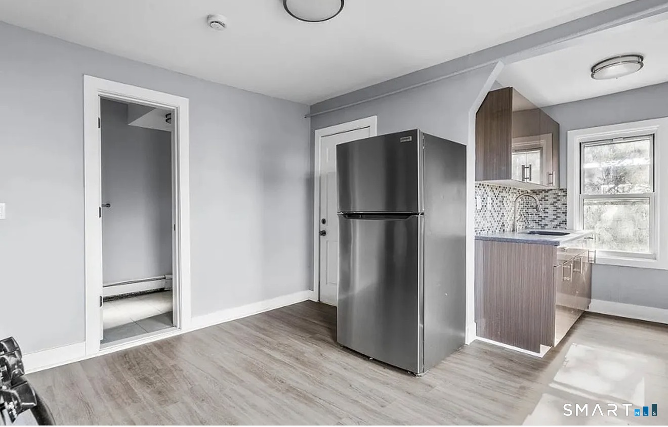 748 Maple Street, Unit 3 Bridgeport, CT 06608 - Photo 5 of 13 a view of kitchen with a refrigerator cabinets and wooden floor