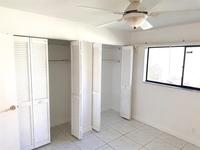 en empty room with windows and ceiling fan