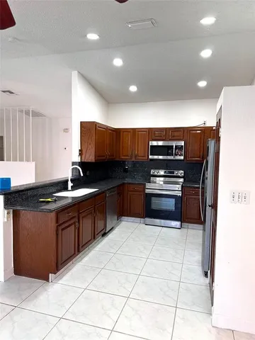 a kitchen with stainless steel appliances and a counter top space