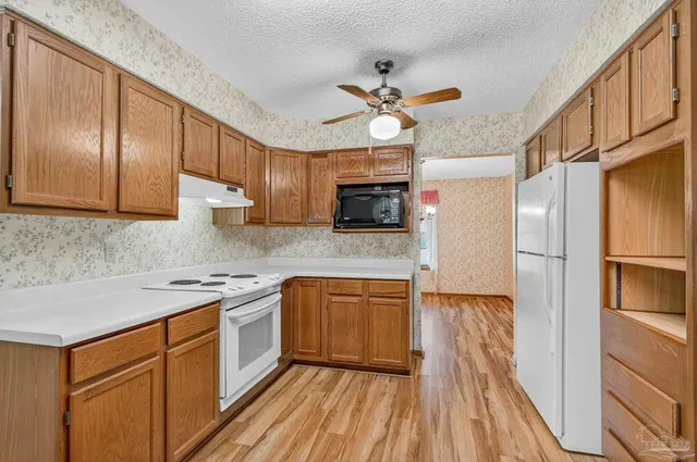 a kitchen with a sink appliances cabinets and a counter top space
