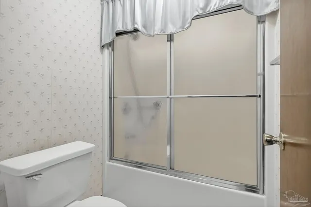 a bathroom with a toilet and a shower