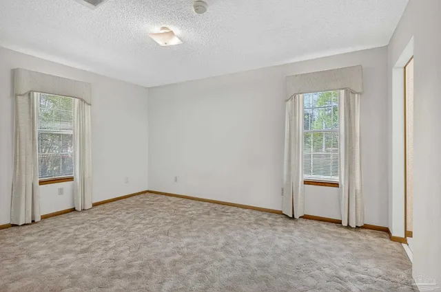 an empty room with closet and windows