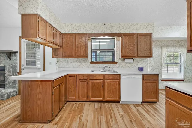 a kitchen with stainless steel appliances granite countertop wooden cabinets a sink and a stove