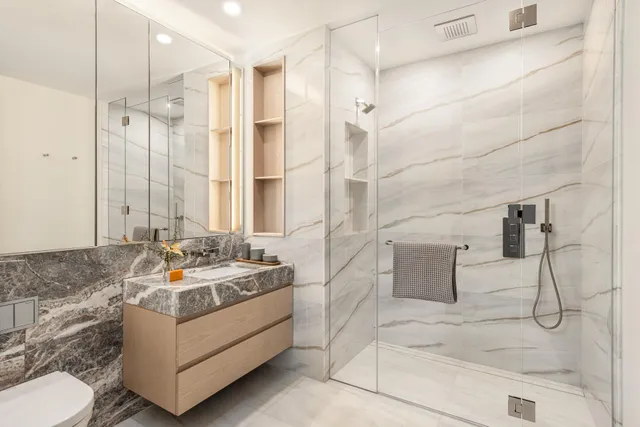 a bathroom with sink mirror and shower