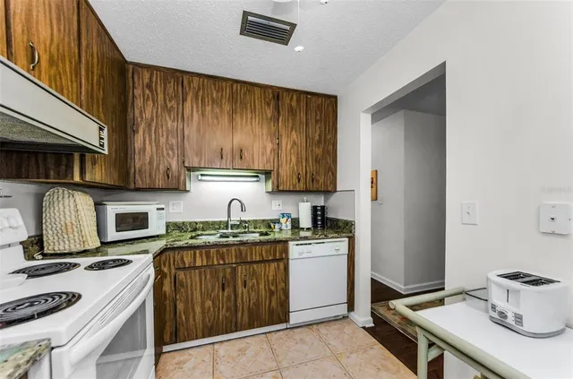 a kitchen with a sink a stove and cabinets
